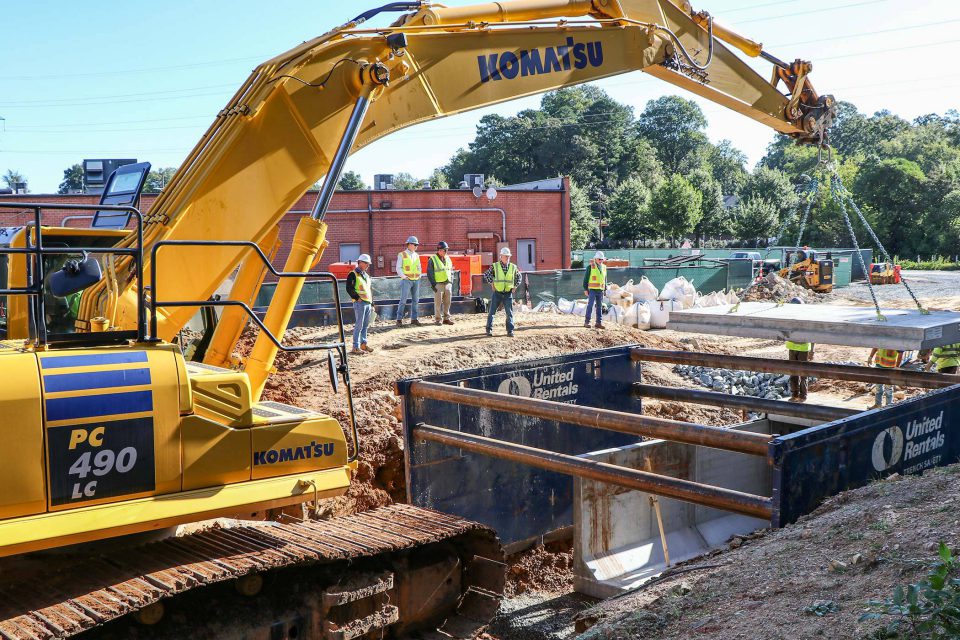 HALL employees lowering project material with heavy machinery