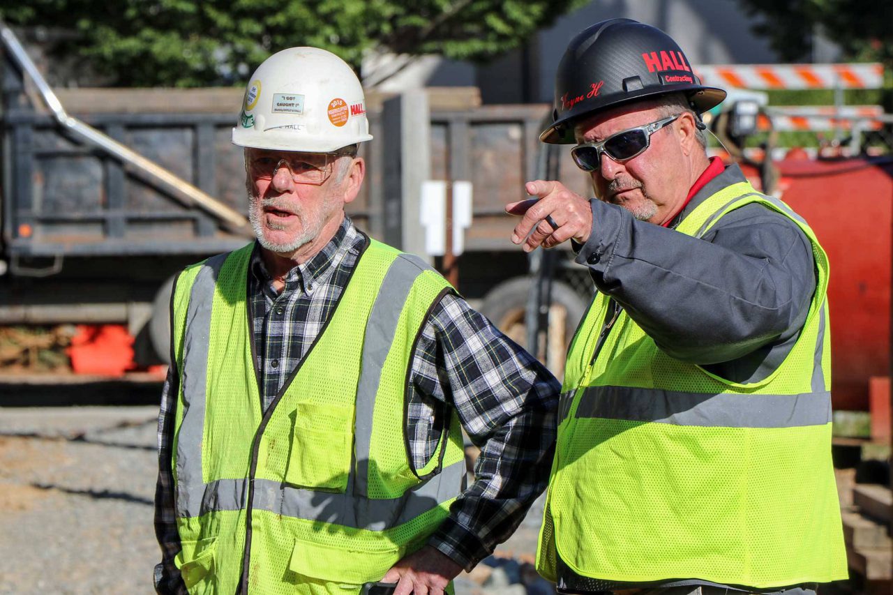 HALL employees standing next to one another discussing project