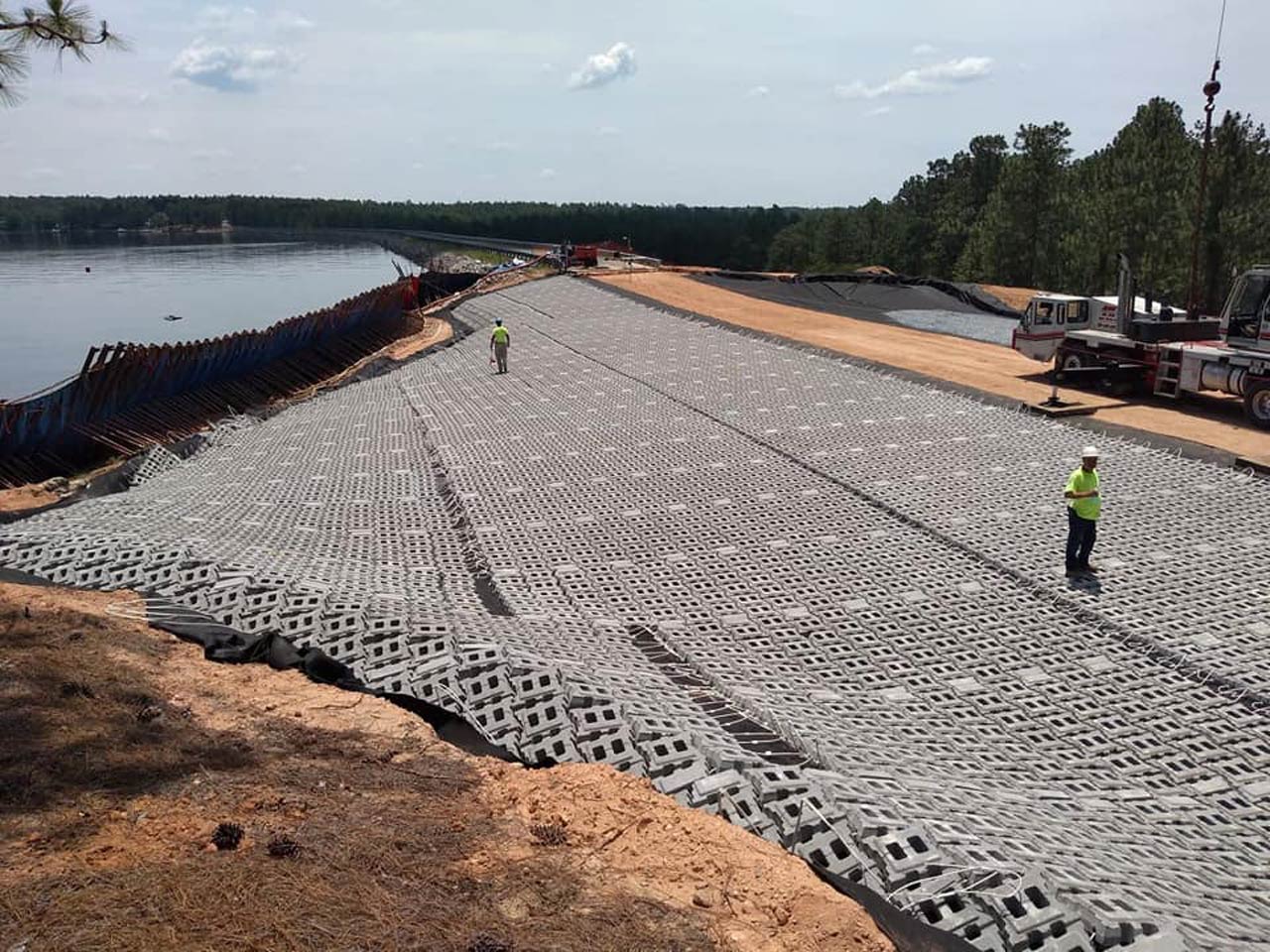 HALL employees stand on the mats for Lake Auman Dam