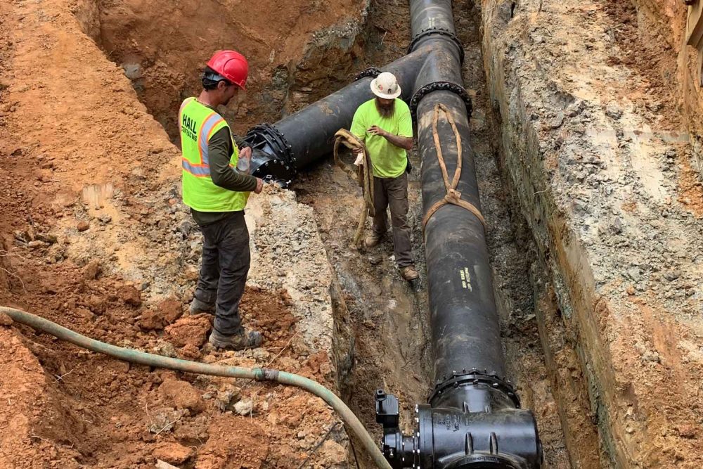 HALL Contracting Corporation employees work together to lay out 20 inch force main